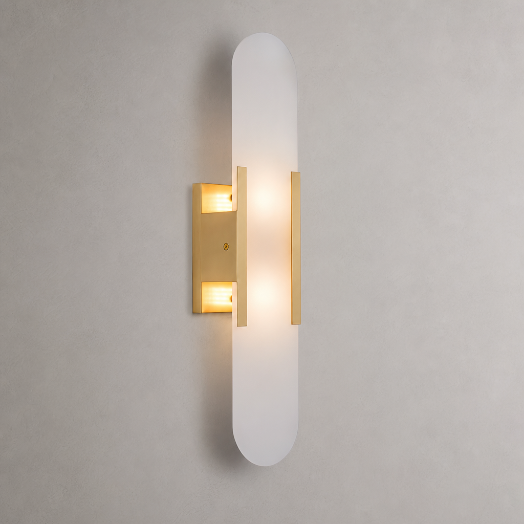 Frosted vertical wall sconce with warm brass accents and glowing light.