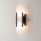 Warm glowing black wall sconce with frosted rounded vertical diffuser on a neutral wall.