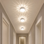 Three decorative ceiling lights cast floral patterns along a hallway ceiling.