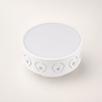 White round bowl with gray heart and dot cutout pattern around the sides.