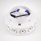White circular LED light fixture with visible driver and wiring on top.