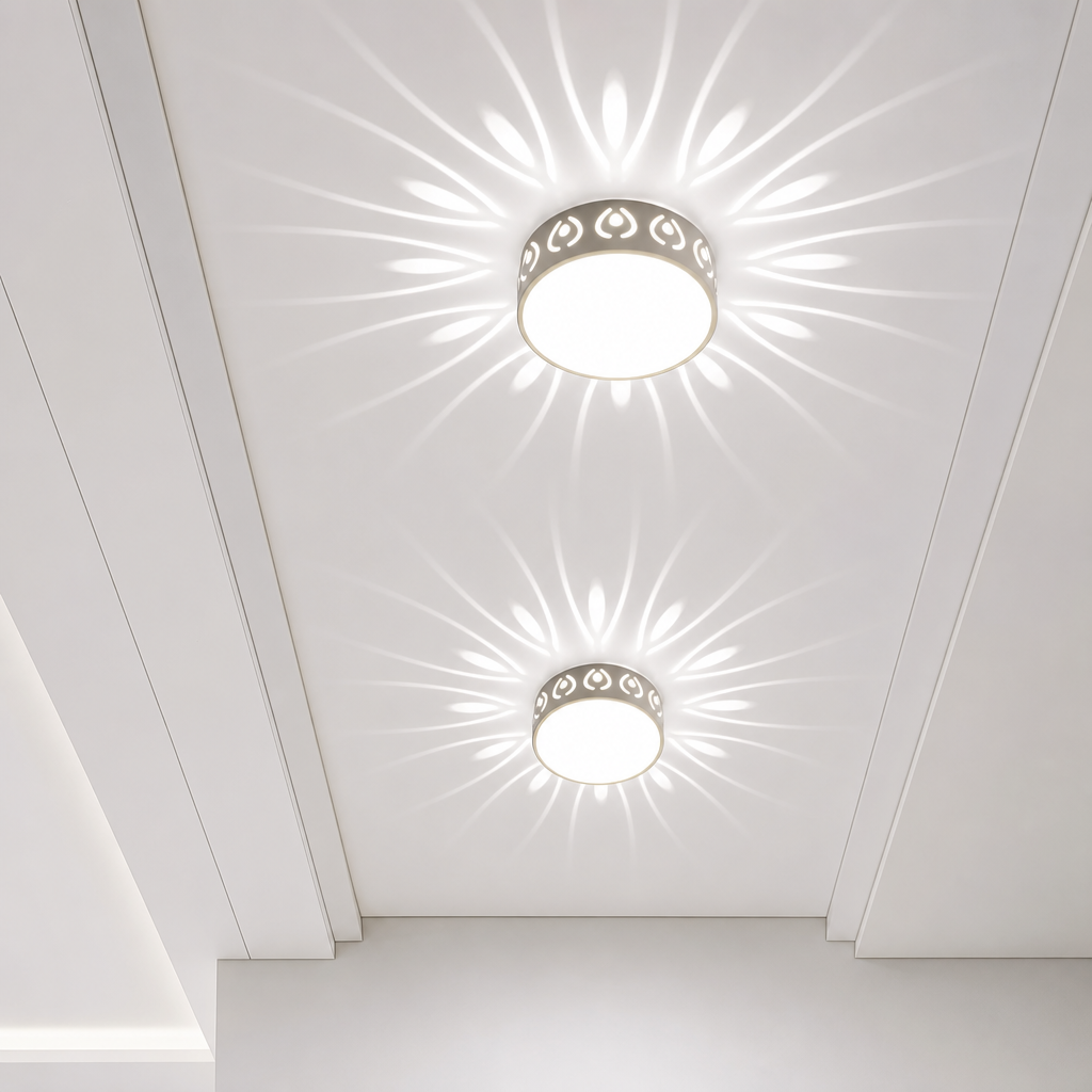 Two round flush ceiling lights with patterned rims casting floral rays on a white ceiling.