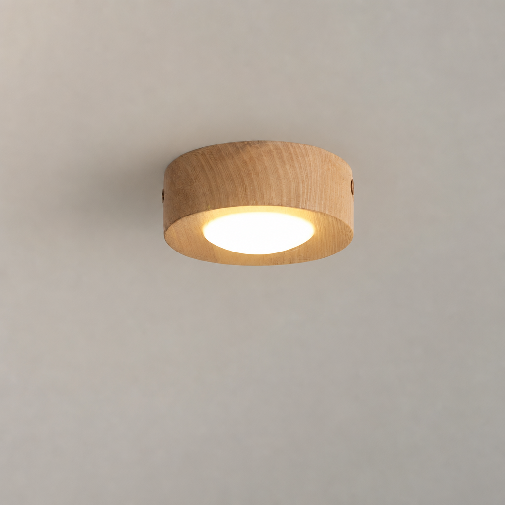 Round wooden ceiling light with a warm glowing diffuser on a plain ceiling.