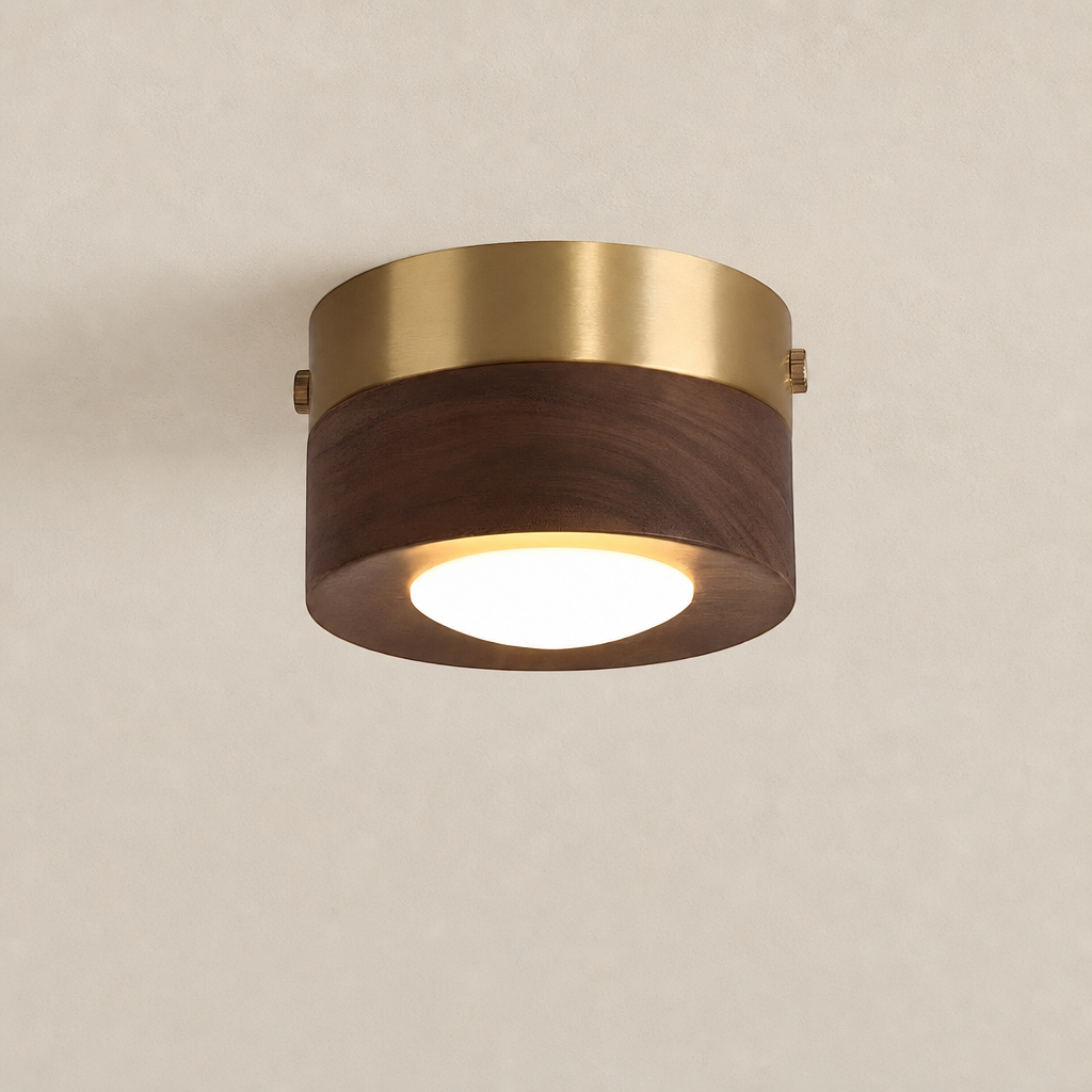 Cylindrical brass and wood ceiling light with a glowing diffuser on a plain neutral ceiling.