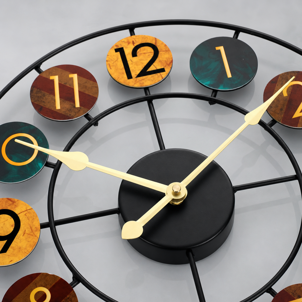Close-up of a modern wall clock with black metal frame, gold hands, and multicolored numbered discs.