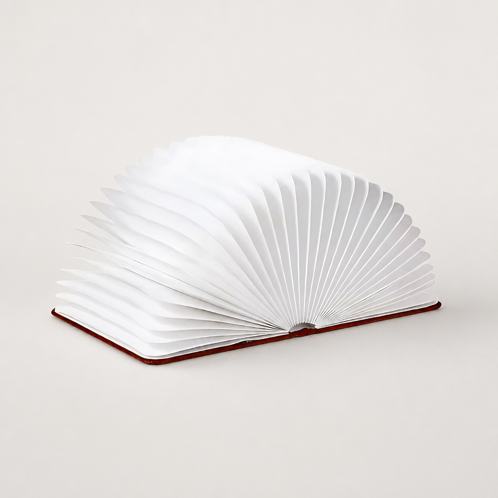White accordion-style open book lamp with fan-shaped pages on a dark red base.
