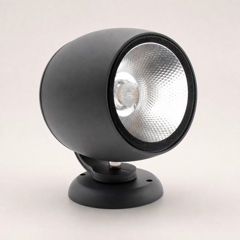 Black cylindrical spotlight with silver reflector on a round mounting base.