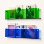 Green and blue transparent wall magazine shelves holding assorted art magazines.