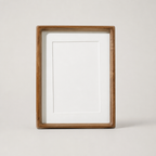 Wooden rectangular photo frame with white mat and blank center on a light neutral background.