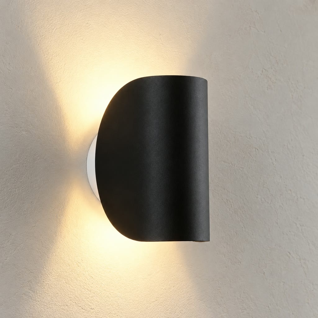 Black wall light showing the curved housing and light spread