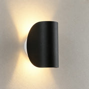 Black wall light showing the curved housing and light spread
