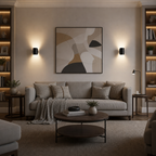 Black cylindrical wall sconces cast warm up-and-down light in a cozy living room.