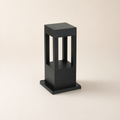 Black rectangular outdoor bollard light with open vertical window panels on a square base.