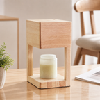 Wooden cube candle warmer with a cream jar candle on a light tabletop.