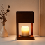 Wooden frame candle warmer with a glowing cream jar candle on a minimalist tabletop.