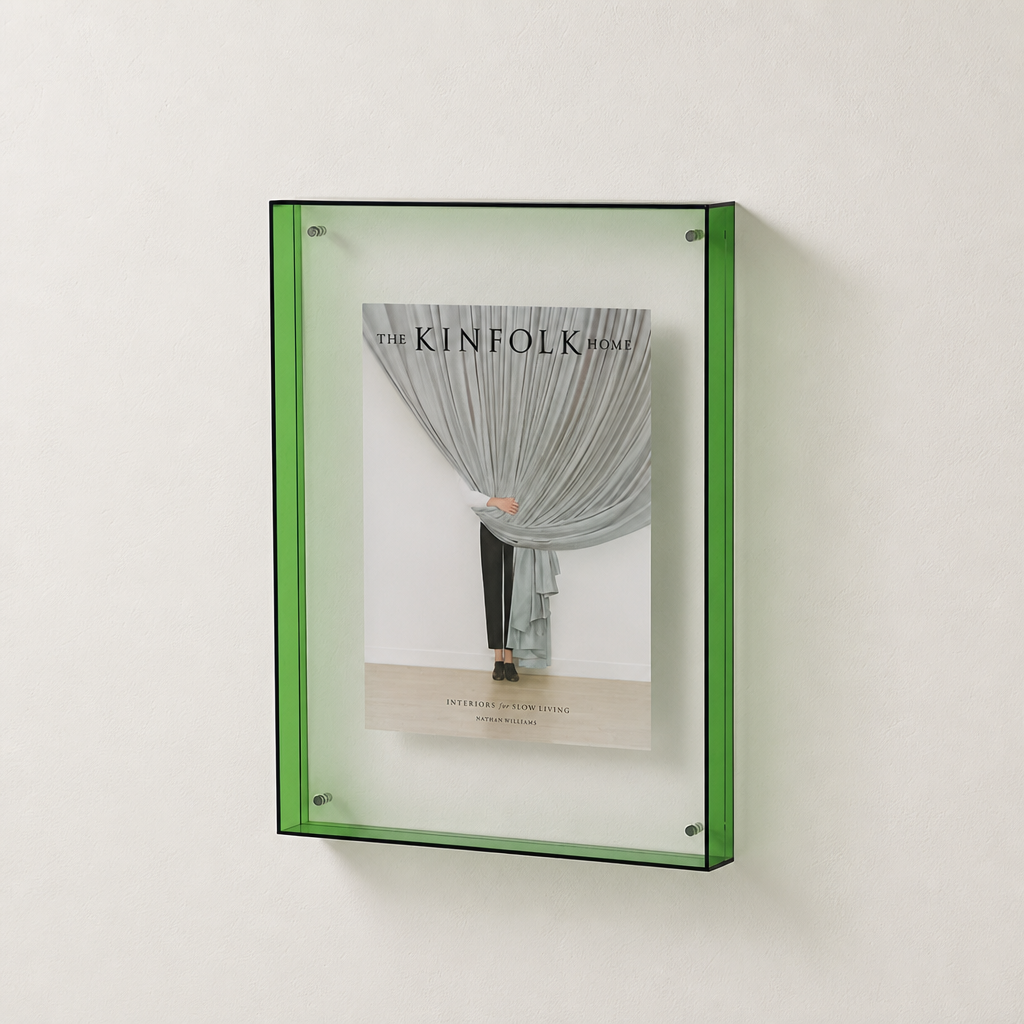 Green translucent wall-mounted display frame holding The Kinfolk Home book