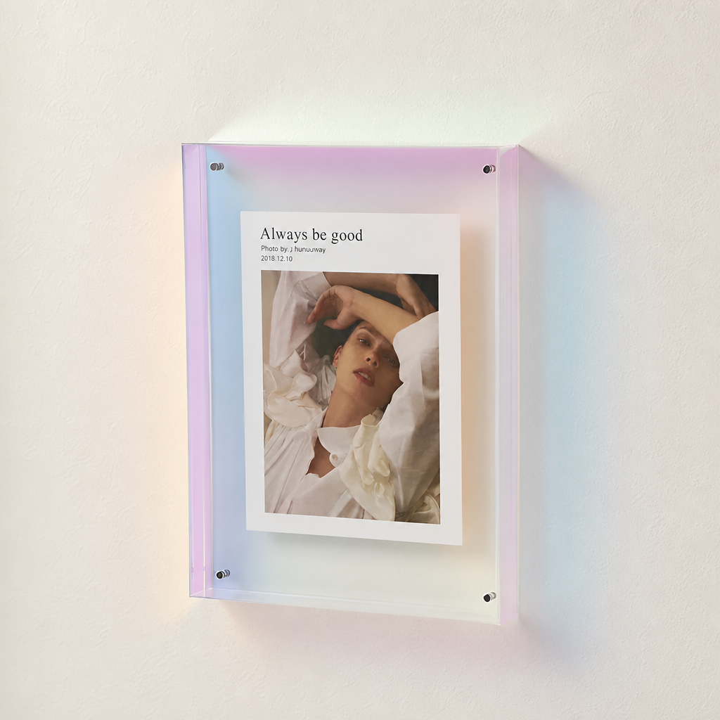 Iridescent acrylic wall frame holding a white photo print with portrait and title text.