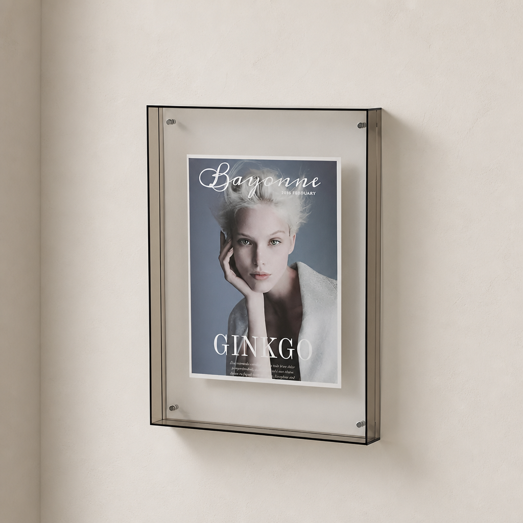 Wall-mounted transparent display frame holding a Bayonne Ginkgo poster.