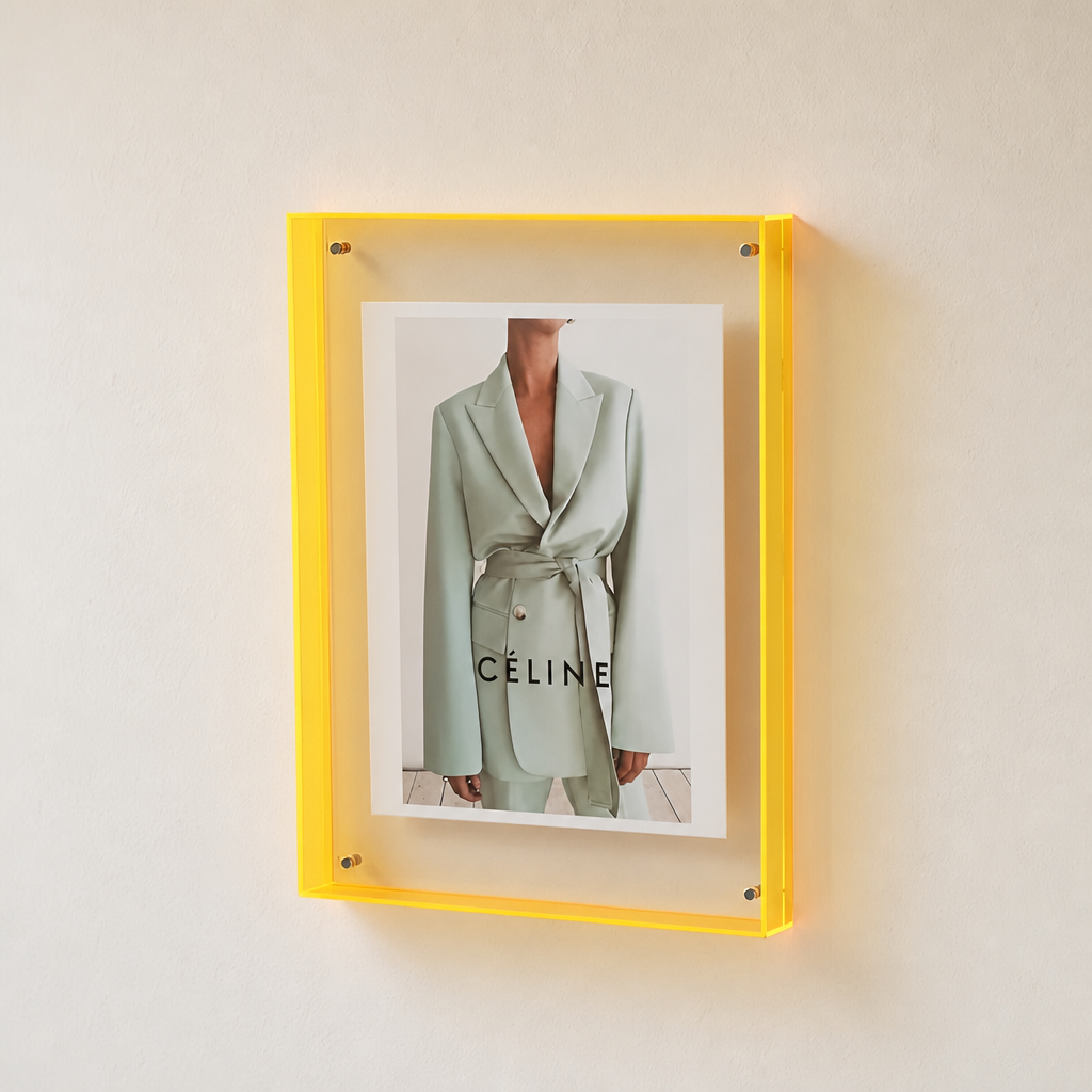 Yellow acrylic wall frame displaying a CÉLINE fashion print.