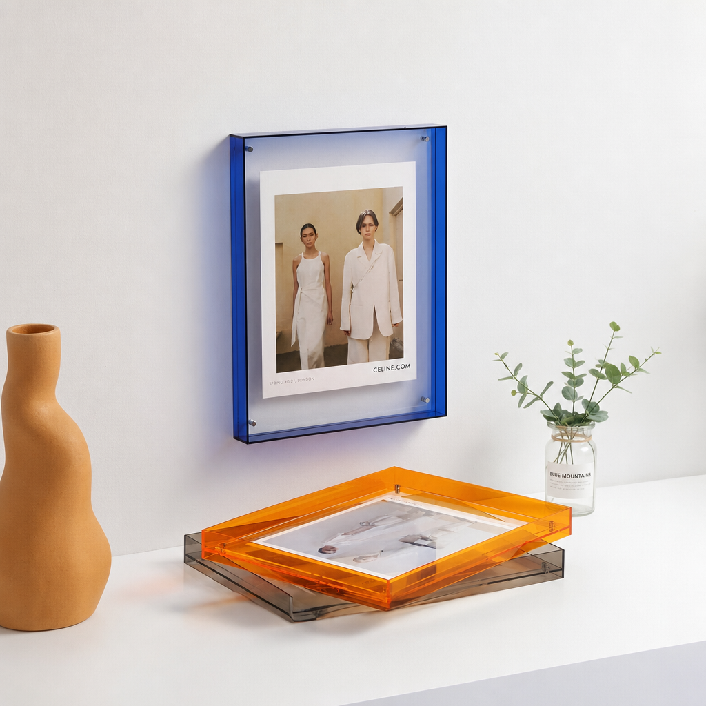 Blue acrylic wall frame and orange acrylic tray displayed on a white shelf.