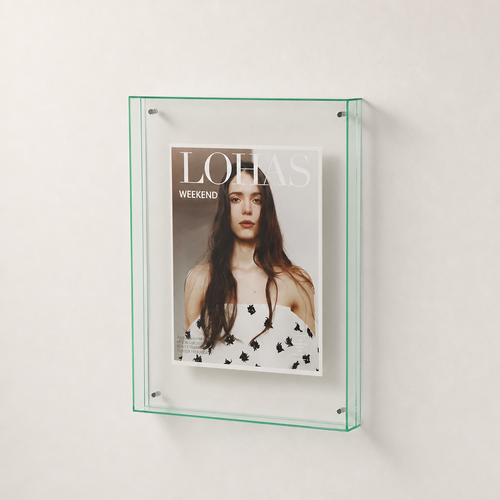 Transparent green-edged wall display frame holding a fashion magazine cover.
