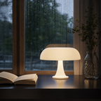 Glowing white mushroom table lamp on a glossy table beside an open book and glass vase.