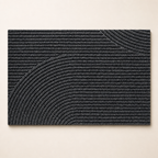 Charcoal rectangular ribbed rug with raised curved arc patterns on a light surface.