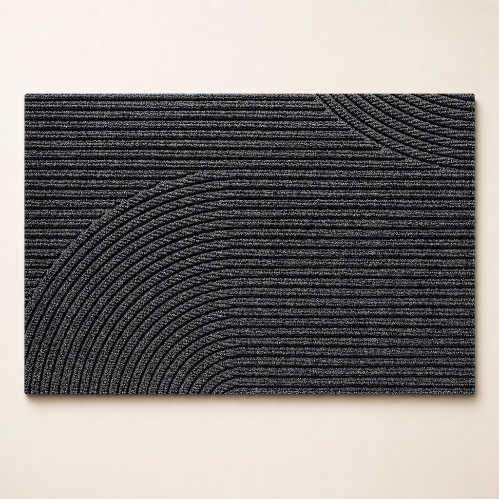 Charcoal rectangular ribbed rug with raised curved arc patterns on a light surface.