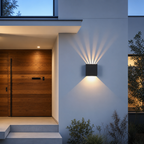 Black wall light casts warm beams on a modern exterior wall.