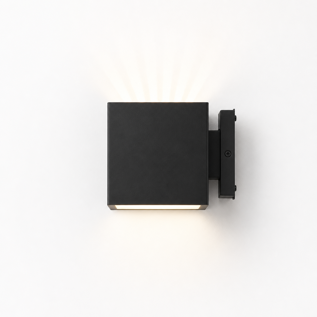 Matte black square exterior wall light with warm glow mounted on a right-side bracket.