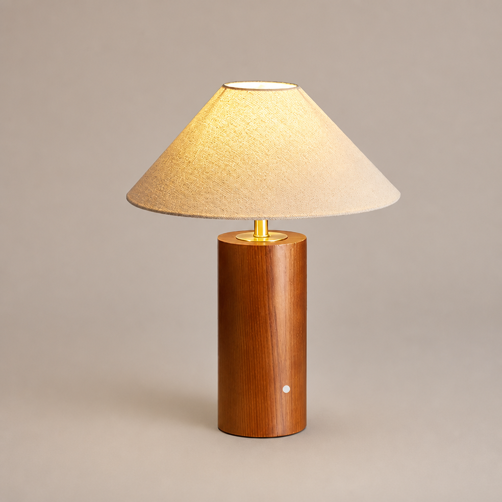 Lit table lamp with beige shade and cylindrical wooden base.