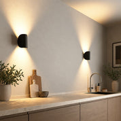 Two black wall lights above a kitchen counter