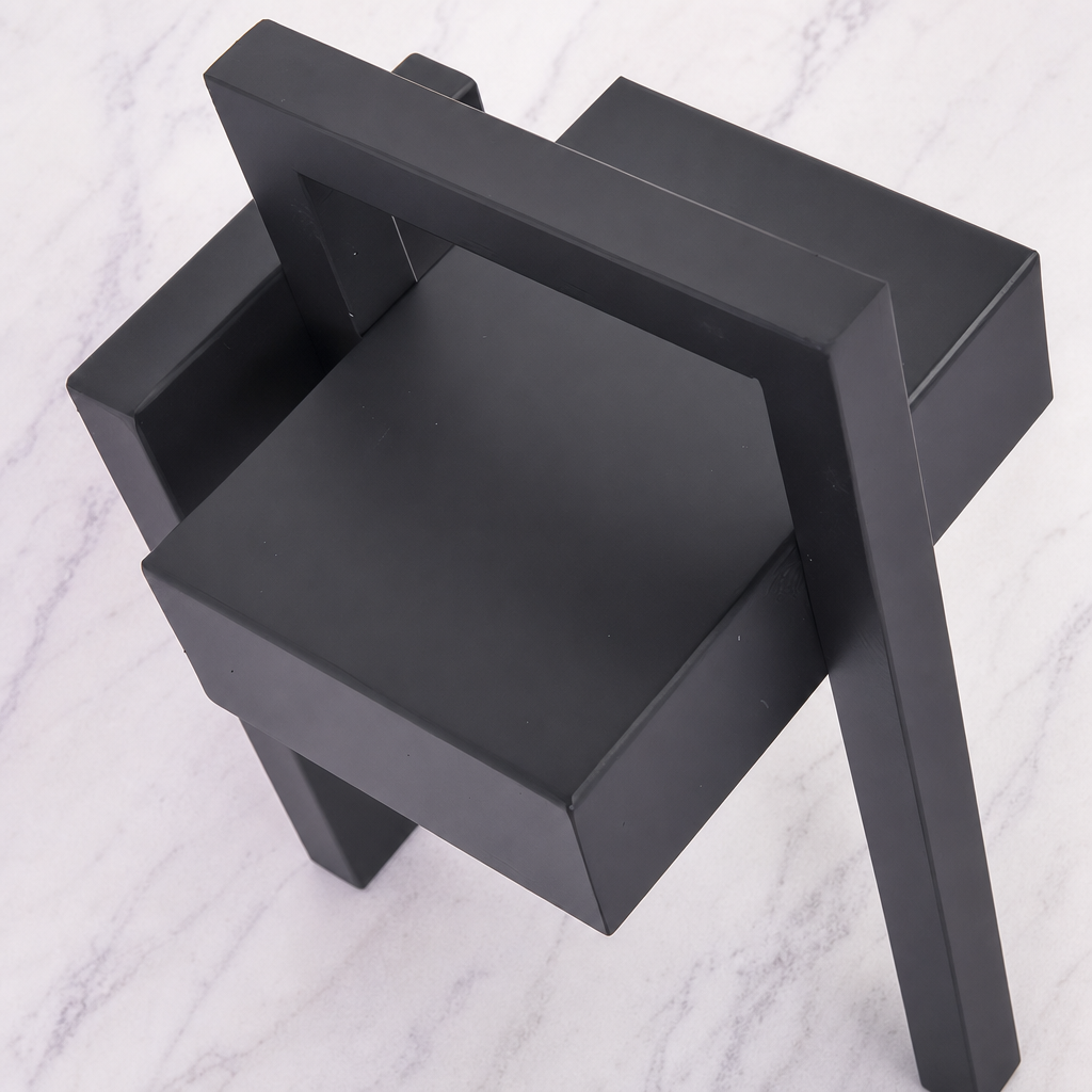 Black geometric shelving unit with angular tiers on a pale marble surface.