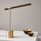 Brass and walnut desk lamp with a slim angled wooden bar on a white surface.