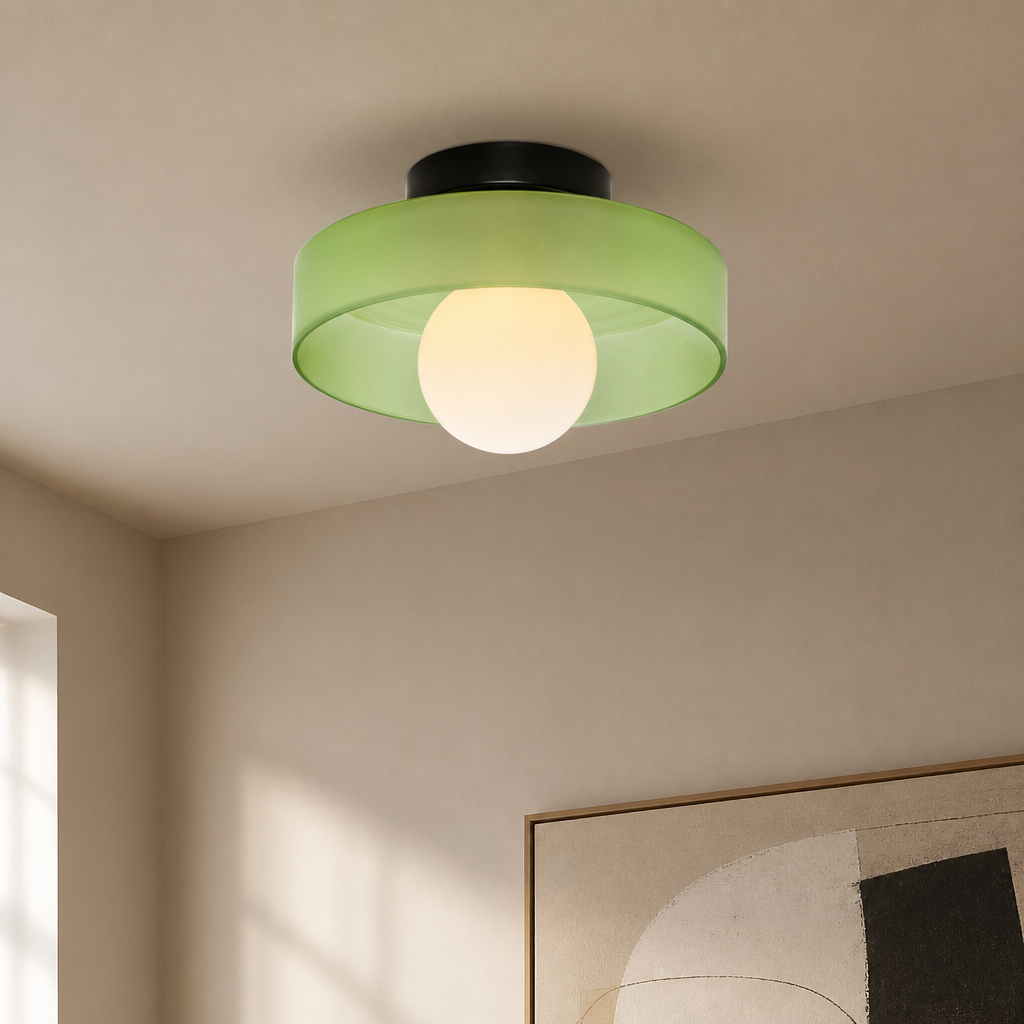 Green flush mount ceiling light with translucent shade and glowing round bulb.