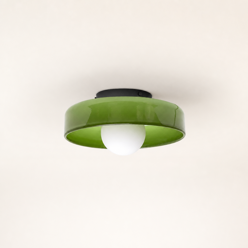Glossy green ceiling light with a white globe bulb and black mount on a plain background.