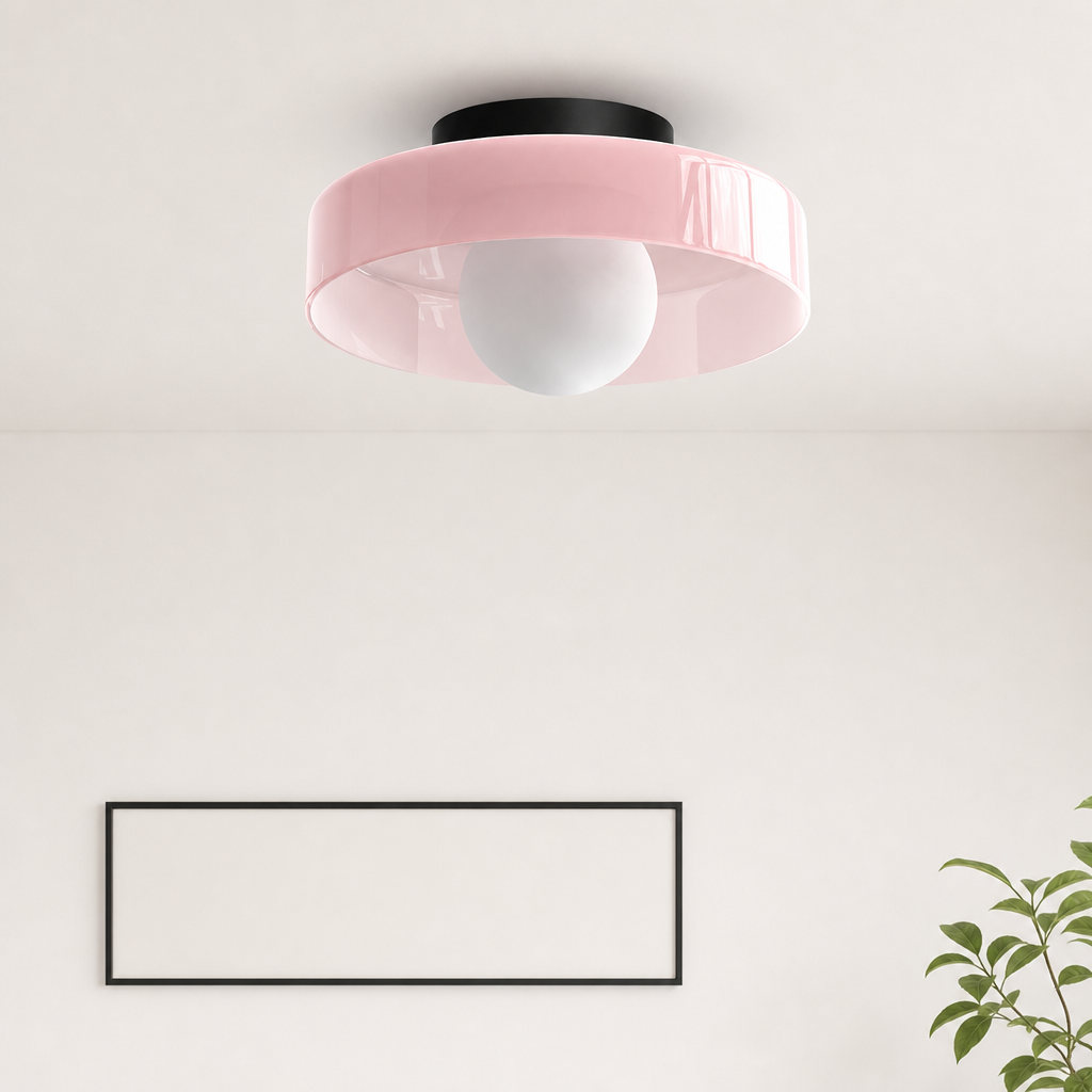 Pink flush mount ceiling light with a white globe bulb and black ceiling cap.