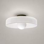 White flush mount ceiling light with round translucent shade and central frosted dome on a pale gray background.