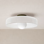 White flush mount ceiling light with a round shade and central globe diffuser.