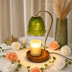 Green glass shade candle warmer lamp with wood base on a floral tabletop.