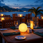 Glowing spherical table lamp on an outdoor seaside restaurant table at dusk.