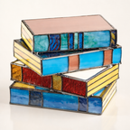 Stacked stained glass book boxes with blue, yellow, red, and peach panels.