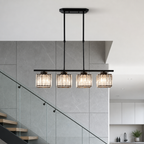 Black linear chandelier with four glowing ribbed glass shades in a modern interior.