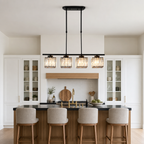 Four-light black linear chandelier with glowing crystal shades over a kitchen island.