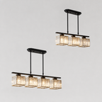Black linear crystal pendant chandeliers with warm glowing cube shades on a gray background.