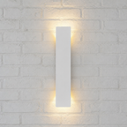 Slim white rectangular wall sconce glowing warmly on a pale textured brick wall.