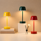 Three glossy mushroom table lamps in yellow, green, and red glow on a warm tabletop.