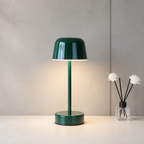 Glossy dark green mushroom table lamp on a white tabletop beside a small white flower diffuser.