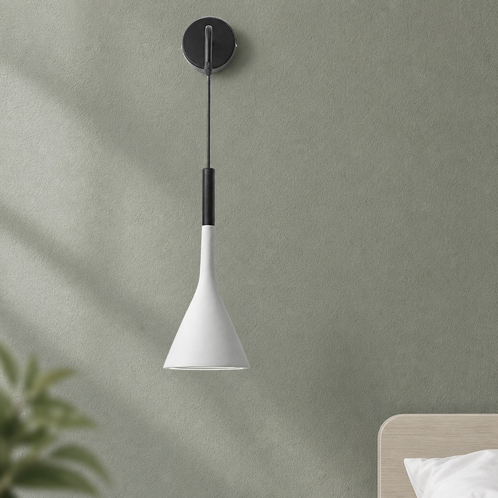 White cone wall pendant lamp with black mount and cord against a muted green wall.