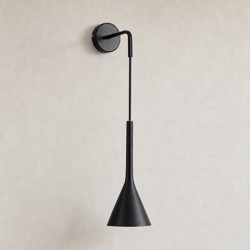 Black wall-mounted sconce with round backplate and tapered cone shade on a light wall.